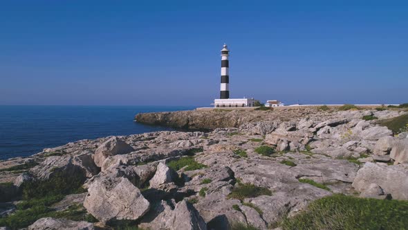 Lighthouse on rocky cliff near sea