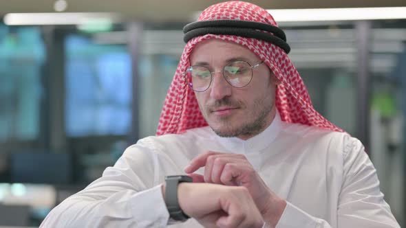 Middle Aged Arab Man using Smartwatch