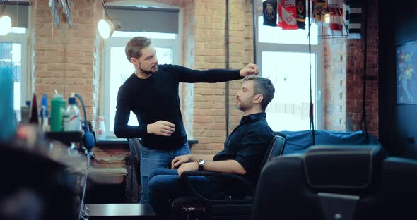 Hairdresser with a Client Discuss a Haircut in a Stylish Brutal Men's Salon