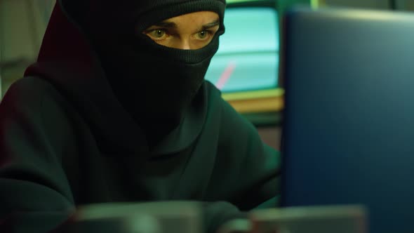 Hacker Wearing Balaclava Stealing Information From Laptop Breaking Password and Looking Around
