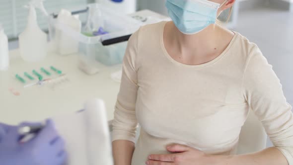 Tilt up video of pregnant woman during a medical interview. Shot with RED helium camera in 8K.