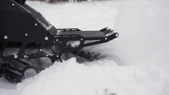 Snowbike Pulls Away and the Snow Flies in Different Directions