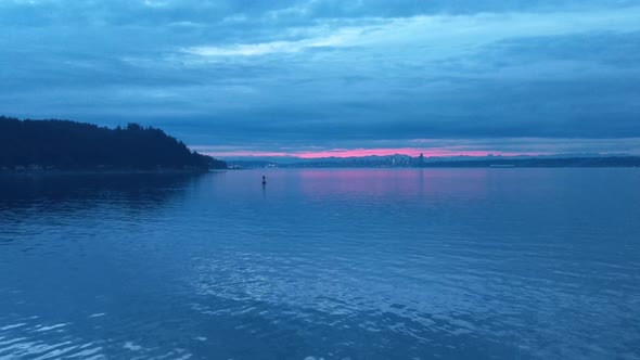 On the bow of the Bremerton Seattle Ferry during the blue sunrise hour, calm water, golden glow in t