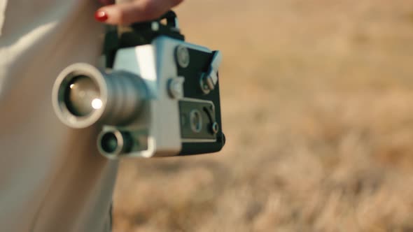 Vintage 8Mm Cinema Camera in the Hand of a Girl Walking in the Countryside