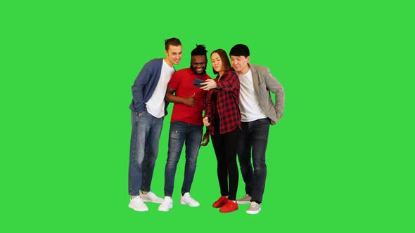 Multiracial Group of Young Friends Make Selfie and Laugh on a Green Screen Chroma Key