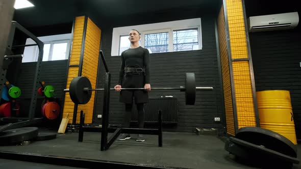 Top View of Fit Man Lifting Barbells in Gym