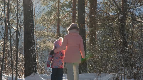 Back View of Child with Mother Walking in Winter