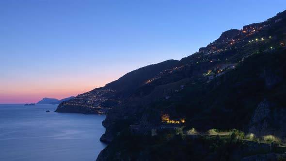 Sunset on the Amalfi Coast with the small town of Praiano on the left. Timelapse zoom in video.
