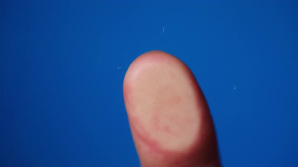 Human Hand Making Thumb Fingerprint on Blue Background