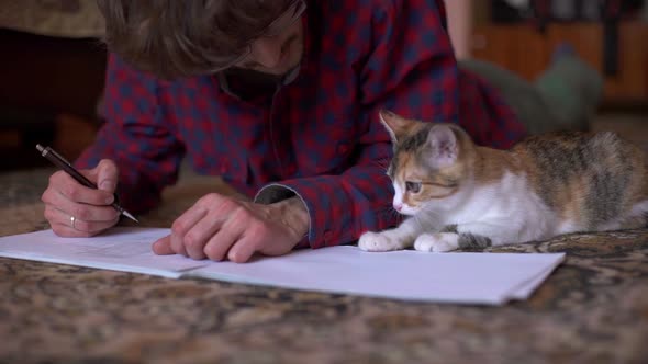 Young Man Playing With White Kitten