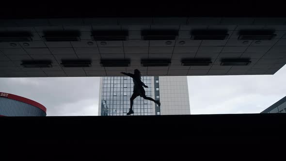 Silhouette Female Person Jumping in Dark Underground Station or Parking