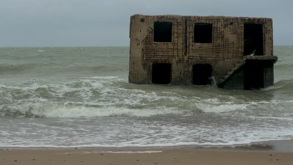 Big stormy waves breaking against abandoned seaside fortification building ruins at Karosta Northern