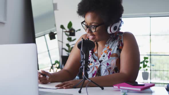 African american female plus size vlogger sitting using computer having a video chat