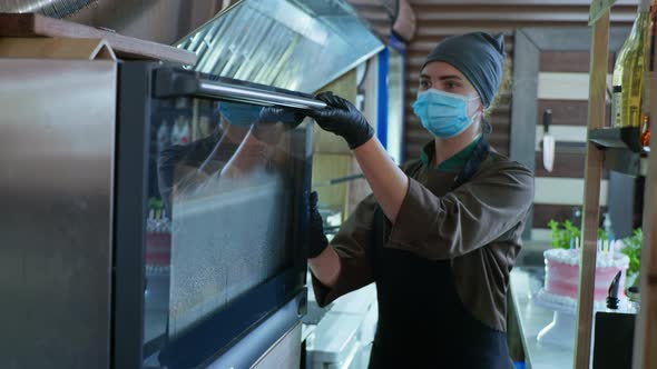 Bake Shop, Female Chef in Medical Mask and Gloves Takes Out Freshly Baked Bread From Hot Oven While