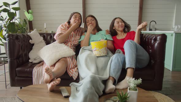 Diverse Women Watching Comedy on TV Laughing Eating Popcorn at Home