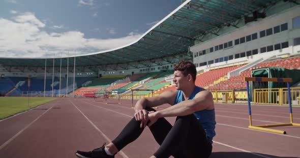 Exhausted Athlete Sitting on Track