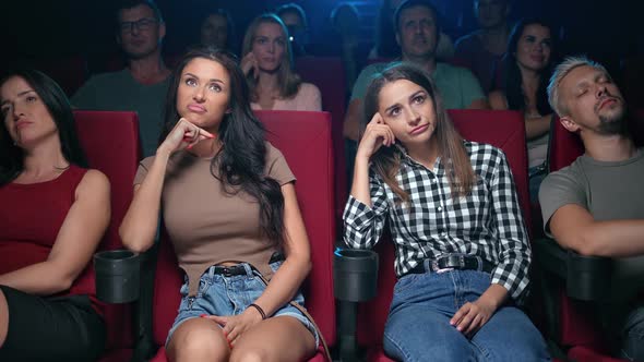 Two Upset Woman Friends Watching Bad Film with Unpleasant Negative Emotion Bored at Cinema