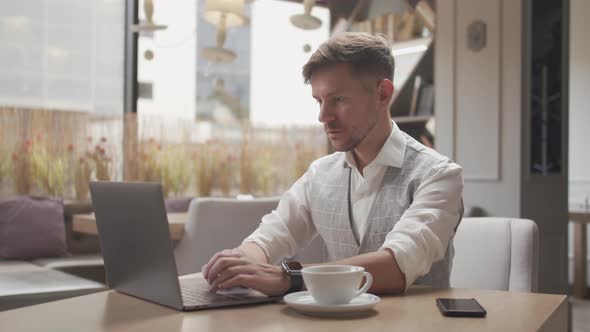 Businessman sitting and working in a cafe. Man using computer.