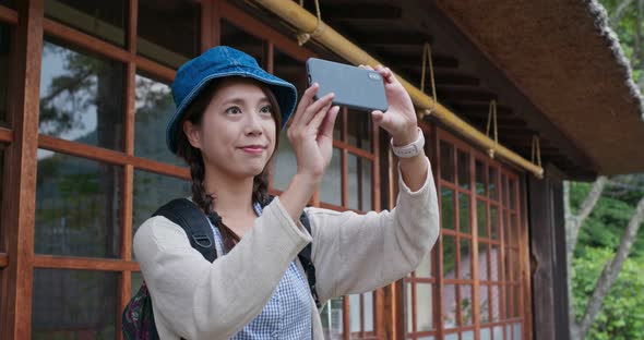 Woman use of cellphone to take photo in Japanese wooden house 