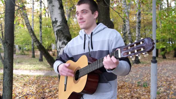 Close up shot of the guitar of a man playing at park. Close up. HD