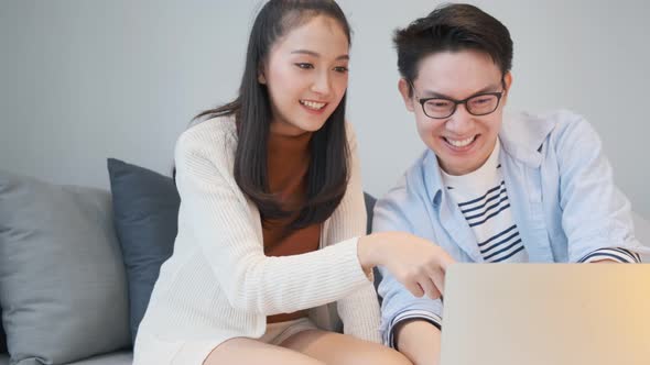 lovely asian young marry couple family enjoy leisure time with laptop entertain