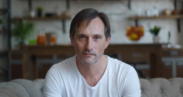 Closeup Portrait of Successful Caucasian Mature Man Smiling Looking at Camera While Sitting at Home