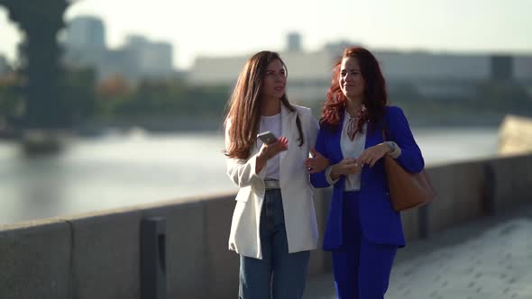 City Walk of Two Adult Business Women at Sunny Day, Ladies Are Going Hand in Hand