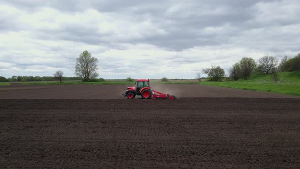 Agricultural Red Small Tractor in the Field Plowing Works in the Field