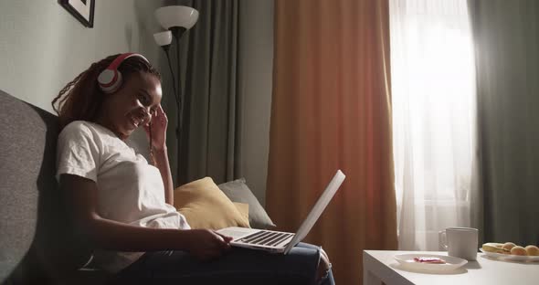 Happy African American Woman Watching Movie on Sofa