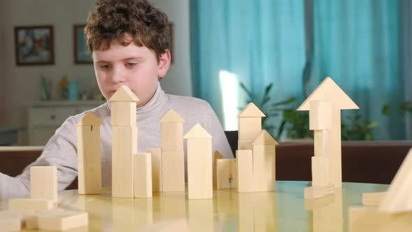 boy creatively builds a building out of bricks. Board educational game.