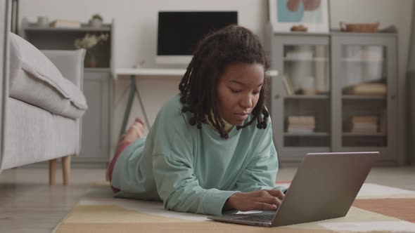 Female African Student Using Laptop at Home