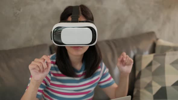 Asian woman with VR headset, watching the 3D virtual simulation.