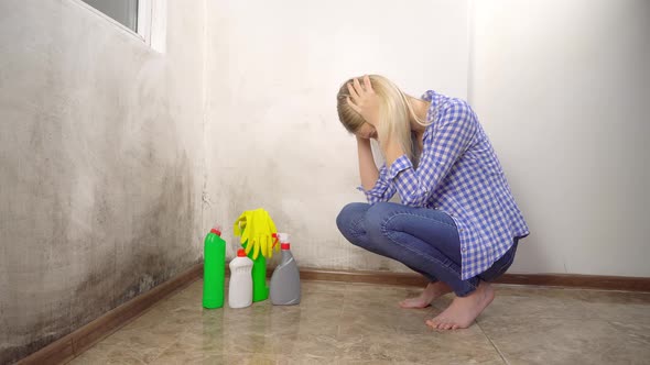 The woman is upset about the appearance of new mold on the wall.