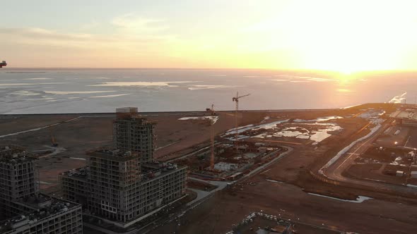 Flying Over Construction Sites on the Sea at Sunset, Aerial Shot