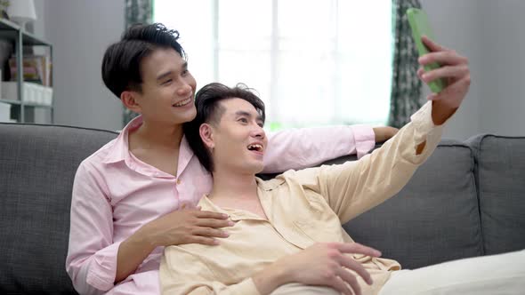 Men Taking Selfie on Smartphone, sitting on a sofa in sitting room, LGBTQ