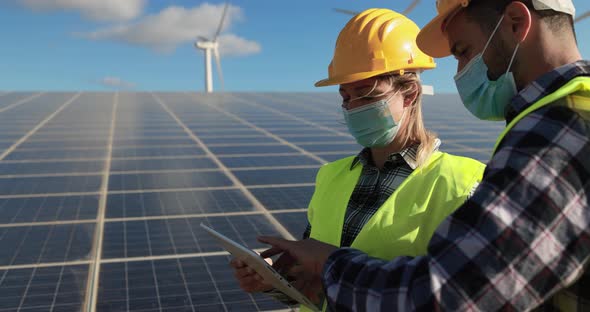 Working people with digital tablet  wearing safety masks- Alternative renewable energy