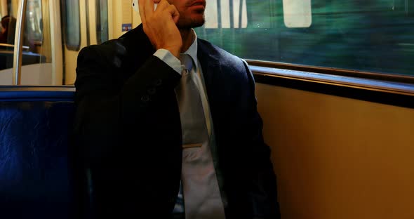 Businessman talking on the mobile phone while travelling