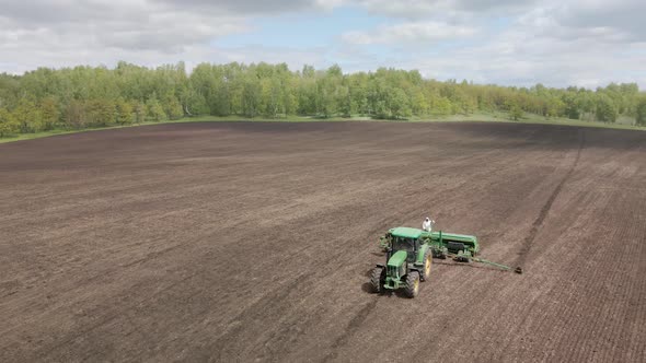 Tractor Plants Seeds On A Plowed Field