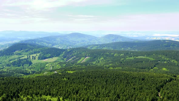 A Vast Hilly Forest Area, the Bright Sky in the Background - Top View