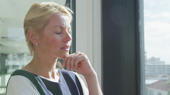 Business woman thoughtful looking through the window