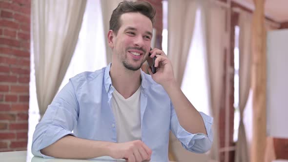 Cheerful Young Man Talking on Smartphone