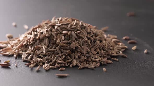 Cumin Seeds Rotating on Turntable on a Slate Background