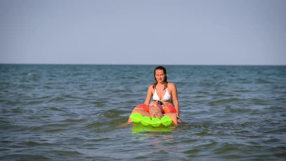 Happy Woman with Children Splashing on the Water Surf