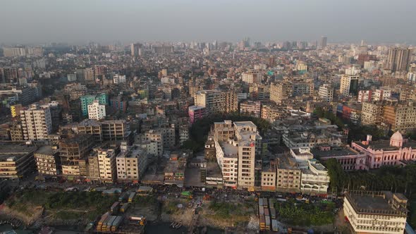 Aerial Dhaka city view with dense buildings and buriganga river- drone pull back shot