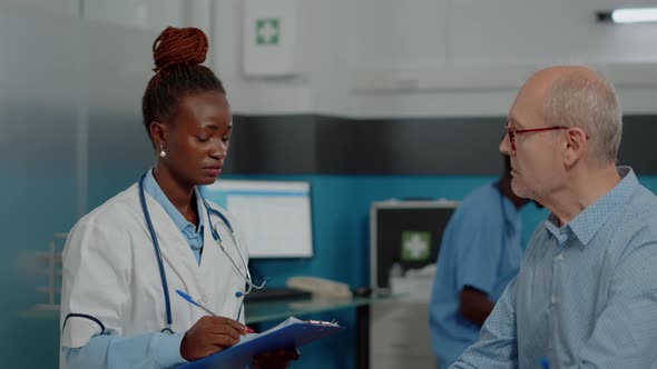 Close Up of African American Medic Talking to Senior Patient