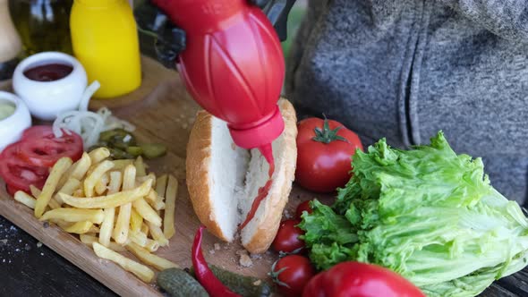 Making Hotdog  Woman Pouring Ketchup Into Bun