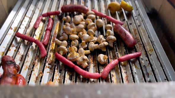 An aerial view of grilling sausages and mushroom on grill with smoke and flame