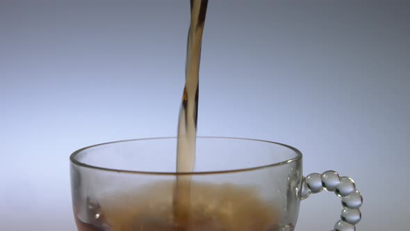Close up of tea being poured into a clear glass in slow motion