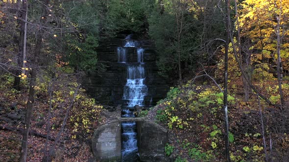 waterfall in fall colored forest approach flight