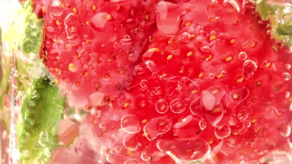 Appetizing Rotation Summer Cocktail Strawberry and Mint in Glass Water Drops and Fizzy Macro Shot